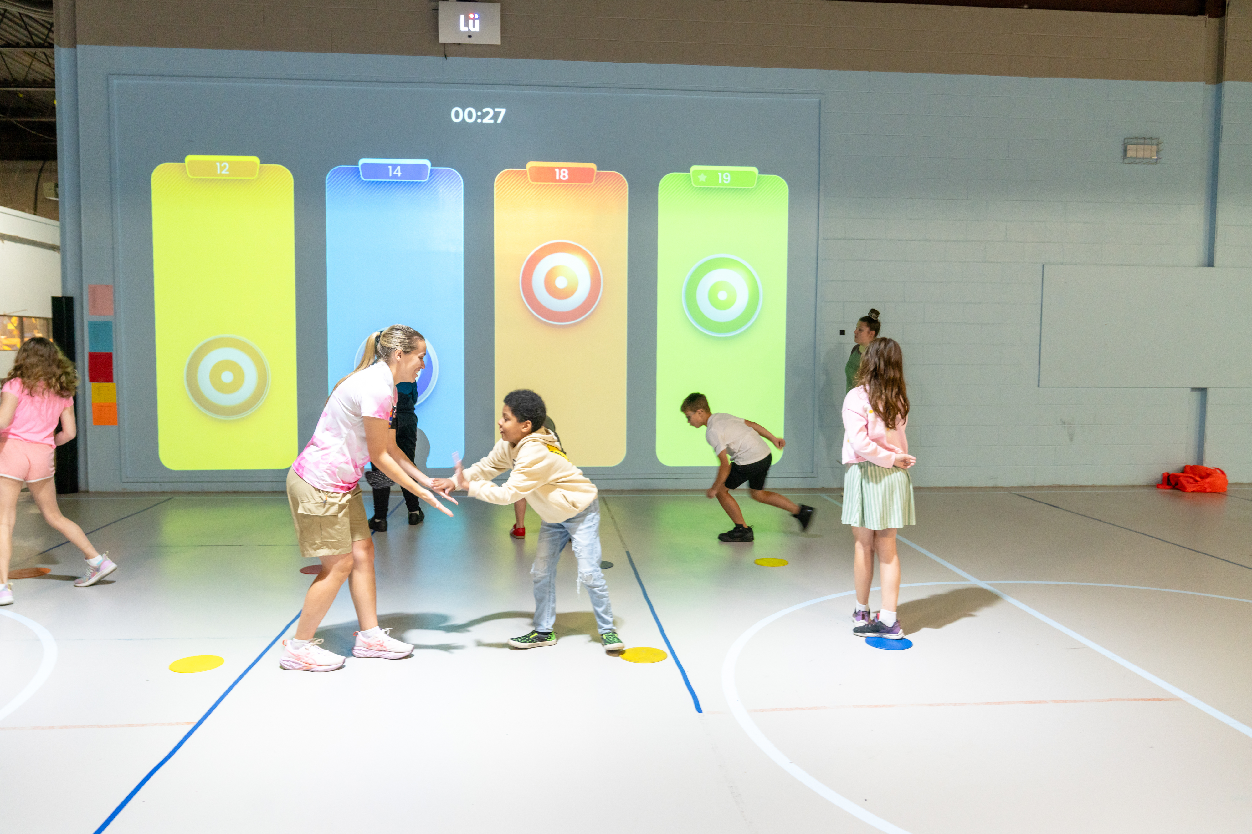 students in front of interactive gym wall
